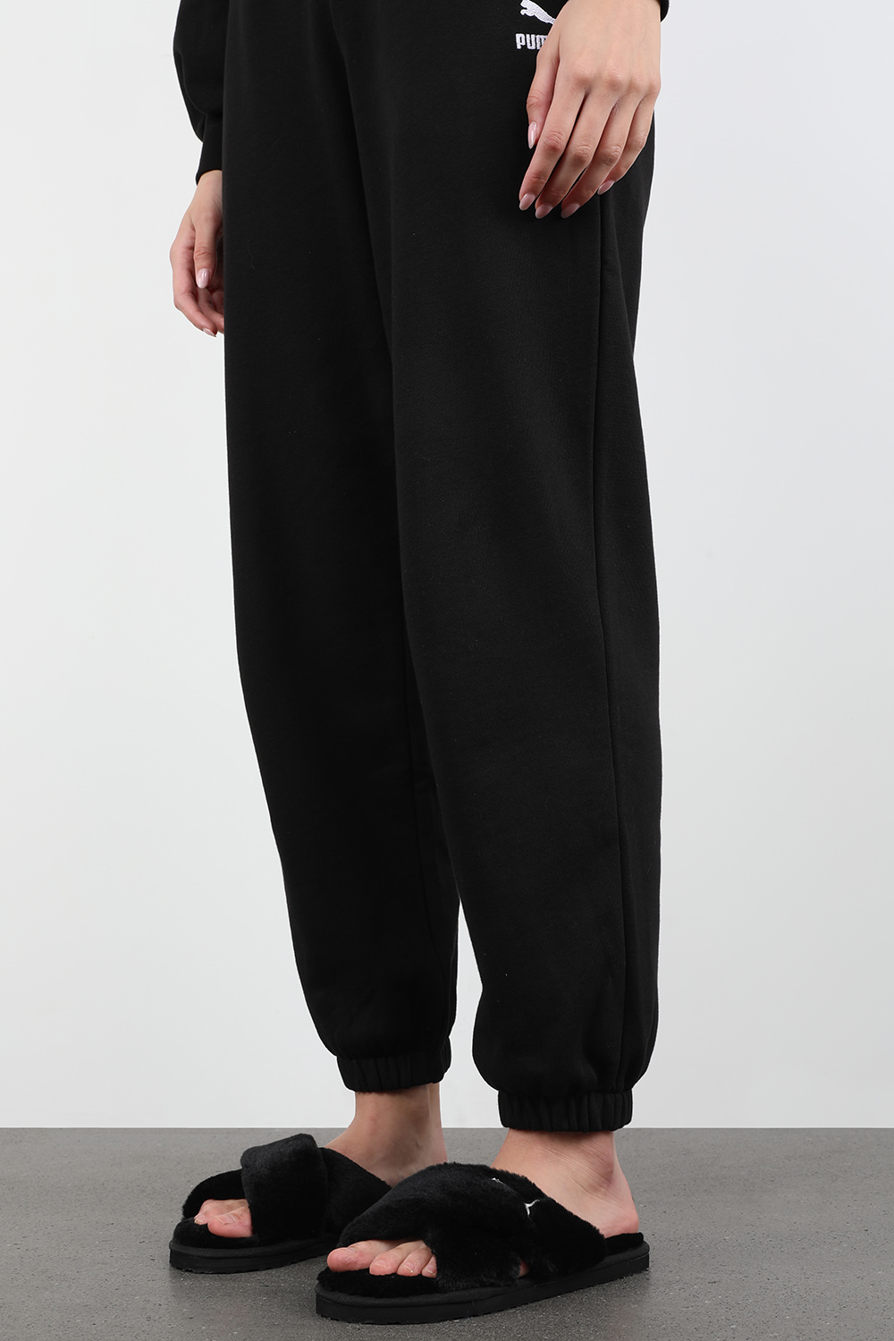 תמונת כל הלוק של כפכפים דמוי פרווה עם רצועות מצטלבות בגוון שחור